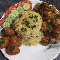 A picture of Gobi manchurian with vegetables rice and chicken nuggets.