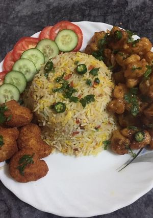 A picture of Gobi manchurian with vegetables rice and chicken nuggets.
