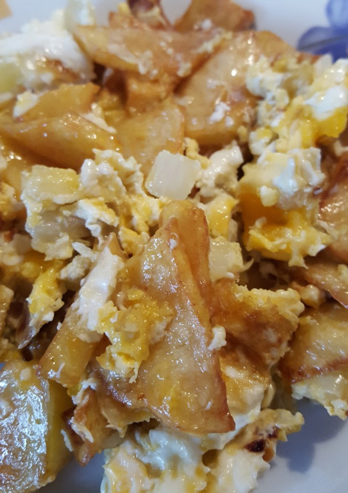 Una foto de Patatas revueltas con huevos y cebollas