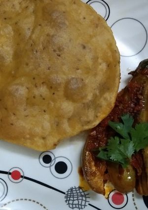 A picture of Kashmiri Khatte Baigan with Khasta Puri.