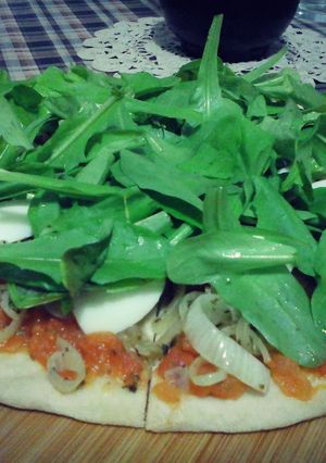 Una foto de Pizza de rúcula, cebolla y huevo
