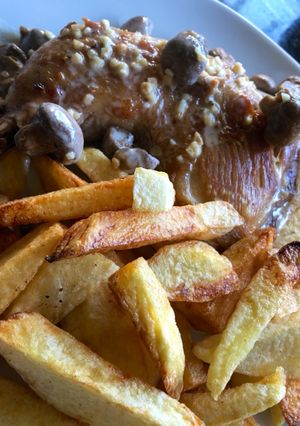 Una foto de Pollo al champiñón con papas fritas
