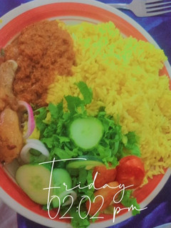A picture of Curry rice with fried chicken in tomato sauce and slide salad.