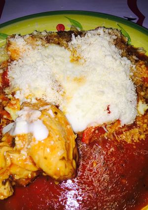 Una foto de Polenta con salsa roja salsa blanca y pollo
