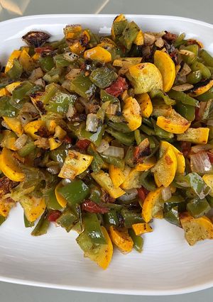 Une photo de Courgettes jaunes, tomate noire et poivrons verts aux épices