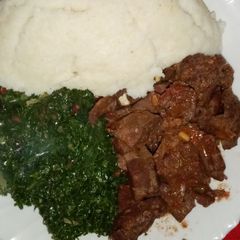 A picture of Ugali with fried liver and greens.