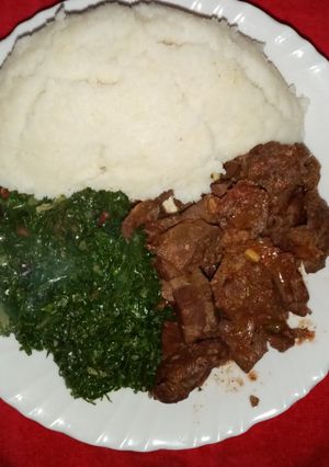 A picture of Ugali with fried liver and greens.