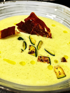 Una foto de Crema de calabacín con crujiente de jamón y topping de calabacín tostado