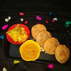 A picture of Kachodi,aalu gobhi fry,pumpkin gravy.