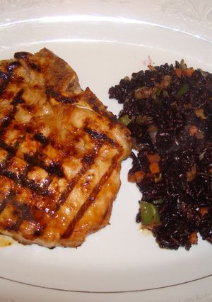 A picture of Grilled szechuan pork chops with black rice.