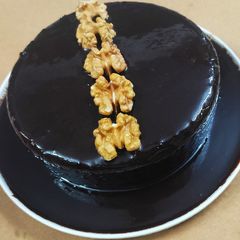 A picture of Brownie cake with chocolate syrup.