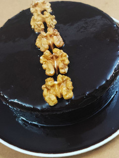 A picture of Brownie cake with chocolate syrup.