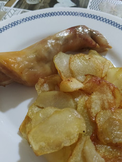 Una foto de Cochinillo crujiente con patatas fritas