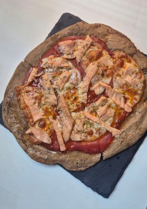 Una foto de Pizza de masa de lentejas con tiras de salmón ahumado