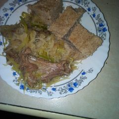 A picture of Brown ugali with mutton and cabbage.