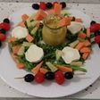 Ensalada de rúcula con guacamole, frutas y queso de cabra