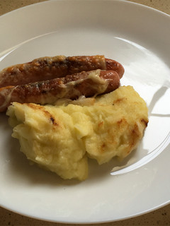 Una foto de Puré de papas y calabacín con salchichas y gratín de queso manchego
