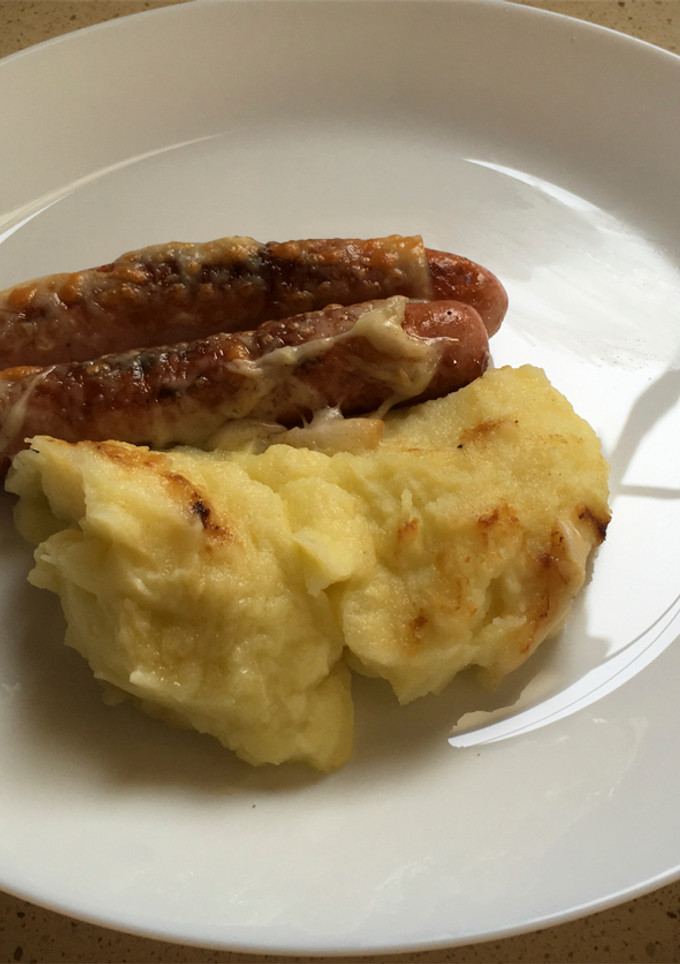 Una foto de Puré de papas y calabacín con salchichas y gratín de queso manchego