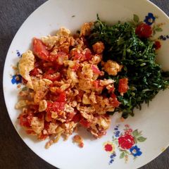A picture of Scrambled eggs with greens.