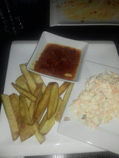 A picture of Fried yam with stew and coleslaw.