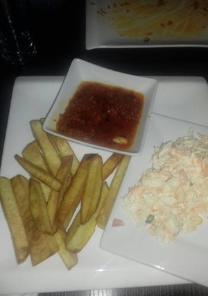 A picture of Fried yam with stew and coleslaw.