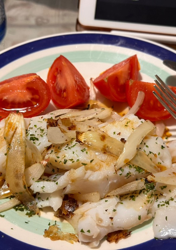 Una foto de Merluza con cebolla, perejil y tomate