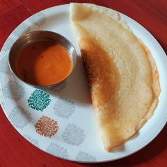 A picture of Dosa with tomato onion chutney.