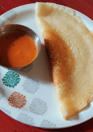 A picture of Dosa with tomato onion chutney.