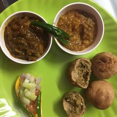 A picture of Litti chokha and meat rasa.