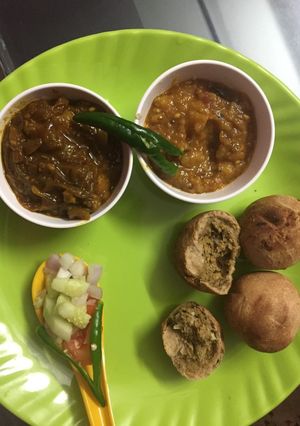 A picture of Litti chokha and meat rasa.