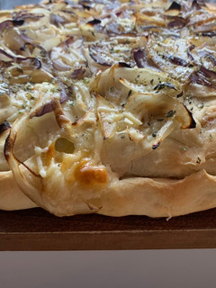 Una foto de Fugazzeta con mix de cebollas y queso parmesano rallado