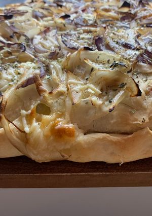 Una foto de Fugazzeta con mix de cebollas y queso parmesano rallado
