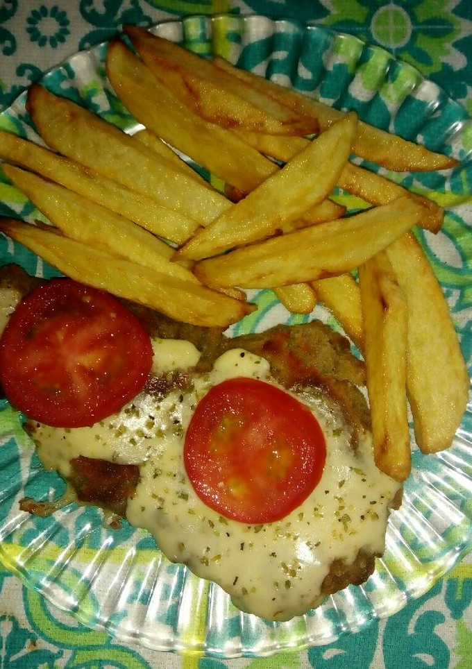 Una foto de Milanesa napolitana, tomate y papas fritas.🙌