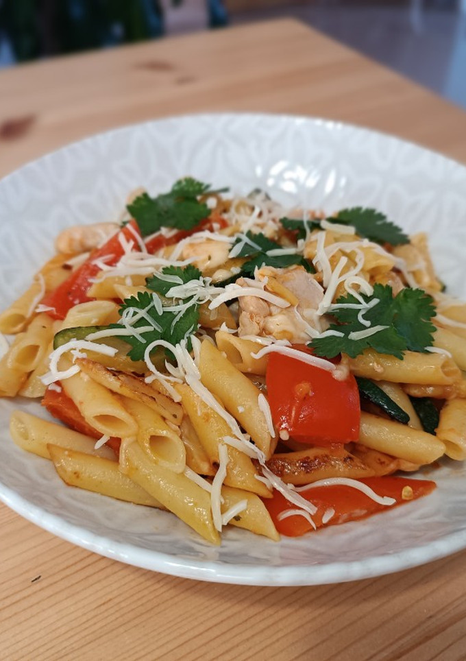 Una foto de Pasta con pollo, calabacín y tomate