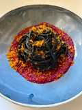 Spaghetti al nero di seppia con bottarga su crema di barbabietola rossa