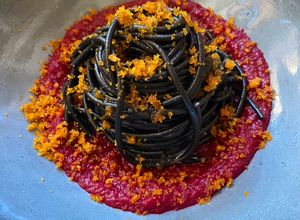 Foto di Spaghetti al nero di seppia con bottarga su crema di barbabietola rossa