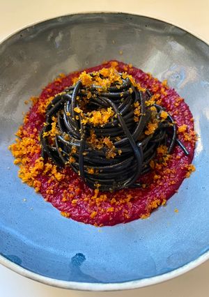 Foto di Spaghetti al nero di seppia con bottarga su crema di barbabietola rossa