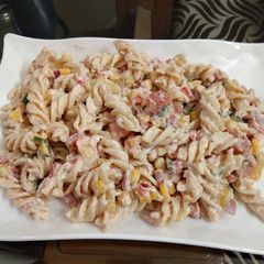 A picture of Pasta in thousand island dressing with sweetness of fruit cocktail.