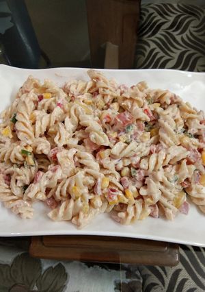A picture of Pasta in thousand island dressing with sweetness of fruit cocktail.