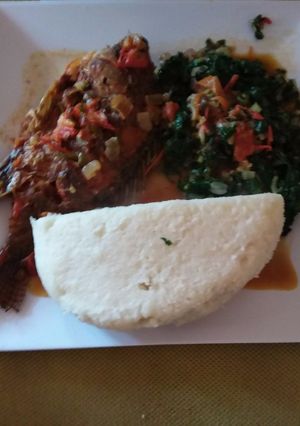A picture of Wet fried fish, ugali and spinach.