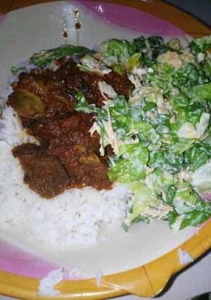 A picture of Rice and soup with salat.