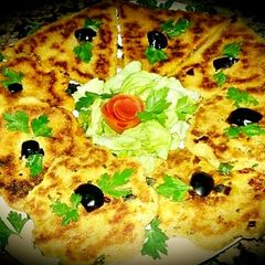 A picture of Algerian bread stuffed with vegetables, cheese, smoked meat.