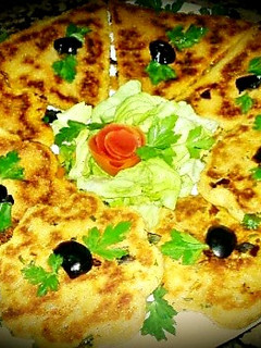 A picture of Algerian bread stuffed with vegetables, cheese, smoked meat.