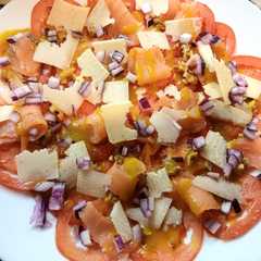 Una foto de Carpaccio de Tomate con Salmón Ahumado, Parmesano y Salsa de Miel y Mostaza