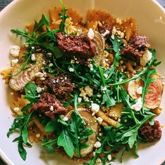 A picture of Farfalle with tomato pesto cream, beets, aragula, beyond meat.