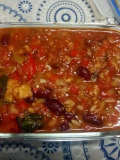 Una foto de Alubias rojas con tomate, espinacas y torreznos de pan