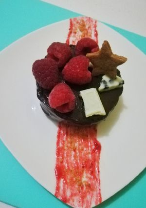 Una foto de Panna cotta de chocolate con coulis de fresa