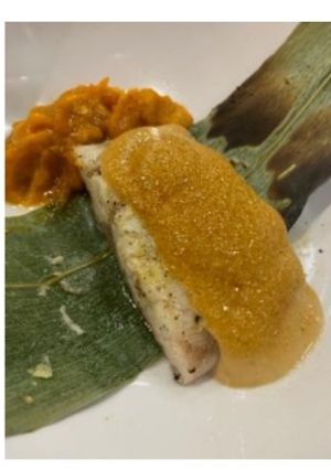 Una foto de Corvina acevichada envuelta en hoja de bambú con mahonesa yakisoba