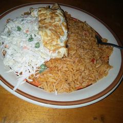 A picture of Jollof rice,vegetable salad and fried egg.