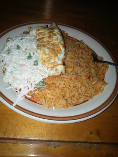 A picture of Jollof rice,vegetable salad and fried egg.